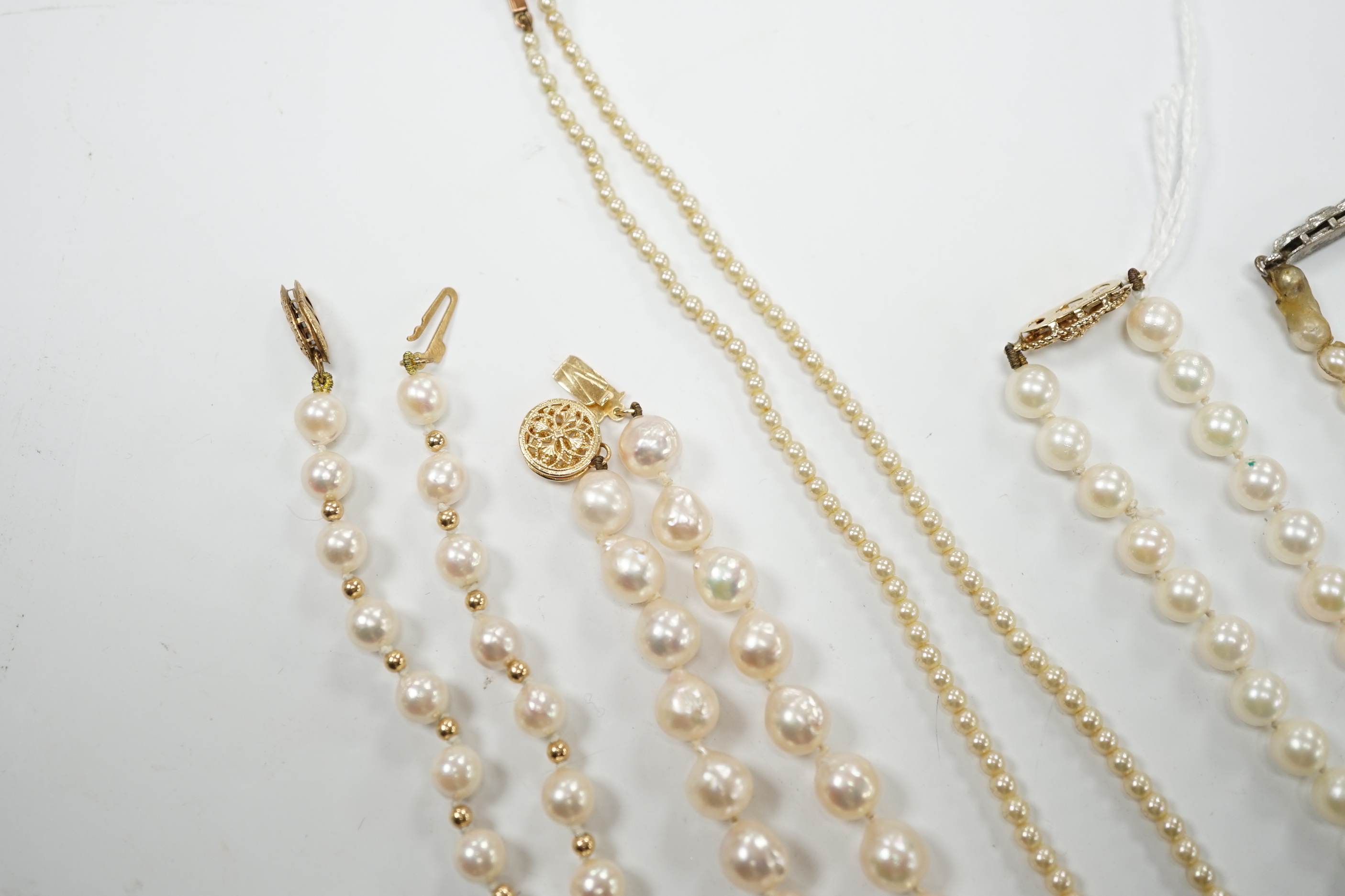 Five assorted single strand cultured pearl necklaces, including four with 9ct clasps, largest 47cm and one other simulated pearl necklace.